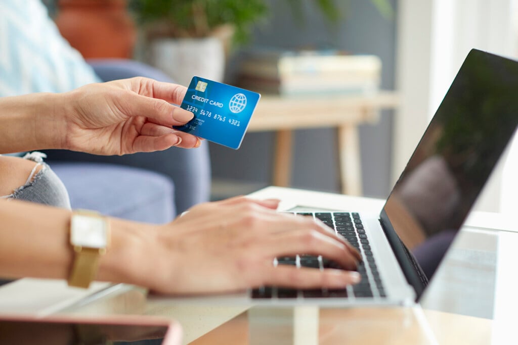 GettyImages woman entering credit card information using laptop