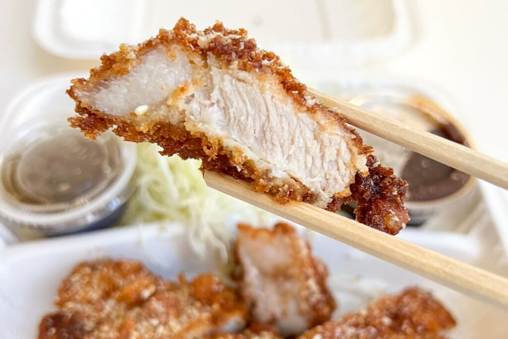 Tonkatsu piece between chopsticks
